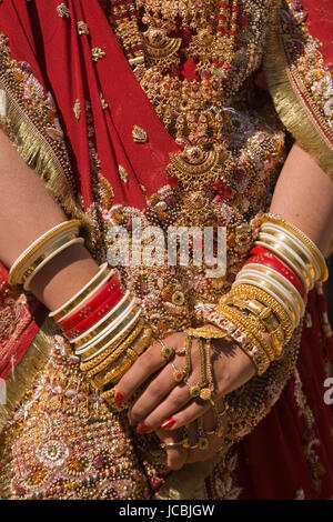 Le mani di un indiano sposa adornata con gioielli schiave e verniciati con colore henné. Foto Stock