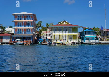 Lungomare di colorate case coloniali oltre il mare con imbarcazioni al dock, Colon, isola di Bocas del Toro, Costa Caraibica di Panama, America Centrale Foto Stock