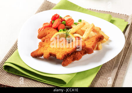 Frittura di Pesce Fritto servito con patate fritte e verdure miste Foto Stock