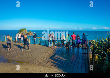 Isola del Sud, Nuova Zelanda - 23 Maggio 2017: persone non identificate guardando wall Island vicino a Cape Foulwind, vista da Cape Foulwind passeggiata a mare Foto Stock