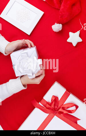 Giftboxes, Santa cap, foto di fiocco di neve e decorativo stella giocattolo su sfondo rosso Foto Stock