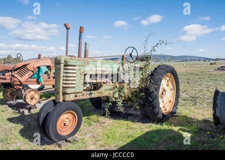 Un vecchio John Deere trattore agricolo in attesa di restauro in un paddock rurale. Foto Stock