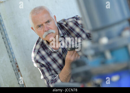 Senior uomo al lavoro in fabbrica Foto Stock