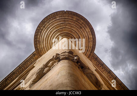La parte inferiore di una torretta su un angolo della costruzione in Barcellona crea un modello geometrico con drammatico, molto nuvoloso sopra. Foto Stock