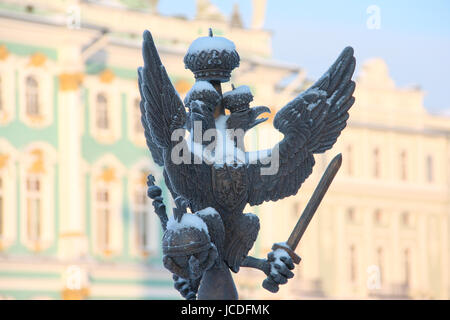 Close up dettagli decorazioni di recinzione con imperiale russa di aquila a due teste simbolo ricoperta di neve sulla Piazza del Palazzo sullo sfondo hermitage Foto Stock