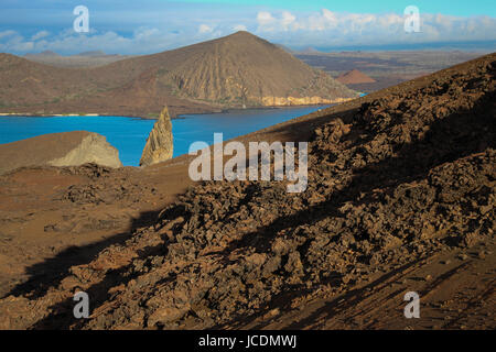 Vista dalla cima del Bartolome isolotto di Galapagos;un vulcano estinto, la sua evidente nelle frastagliate rocce. Iconico pinnacolo di roccia è in background. Foto Stock