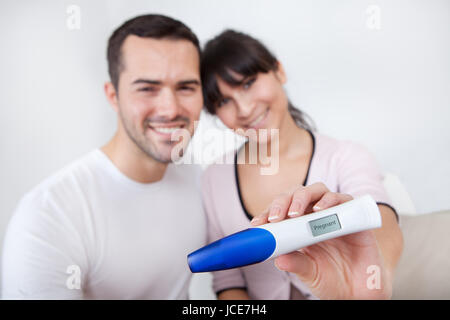 Coppia giovane trovare i risultati del test di gravidanza a casa Foto Stock