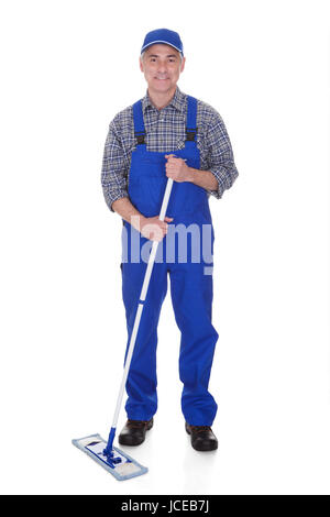 Uomo maturo pulizia pavimento con spazzolone su sfondo bianco Foto Stock