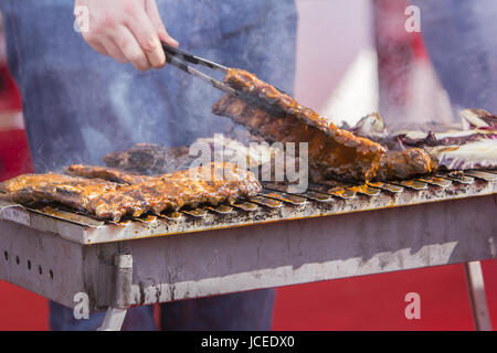 Lo Chef barbecue di carne di maiale alla griglia nervature sulla presenza di fumo Foto Stock