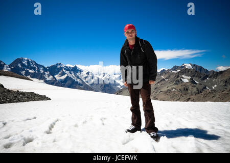 Giovane uomo in piedi sulla vetta del Monte Cook la montagna più alta in Nuova Zelanda, raggiungendo 3,754 metri. Parco nazionale di Mount Cook, Alpi del Sud, South Island, in Nuova Zelanda. Foto Stock