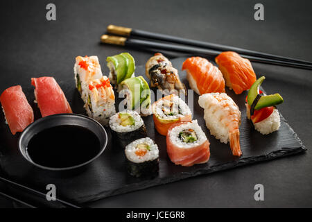 Set di sushi nigiri sushi e panini serviti sulla pietra nero ardesia Foto Stock