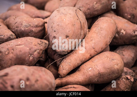 Pila di organico Patate dolci Close Up sfondo. Mangiare sano. Foto Stock