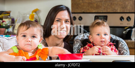 Una madre in cucina pone con neonati Foto Stock