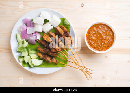 Vista aerea delizioso pollo satay sul tavolo da pranzo in legno, uno dei famosi malese piatti locali. Foto Stock