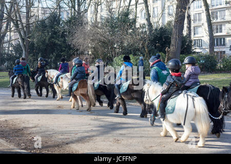 Bambini su pony Shetland dal pony club, Jardin d'Acclimatation, il Bois de Boulogne, Parigi, Francia Foto Stock