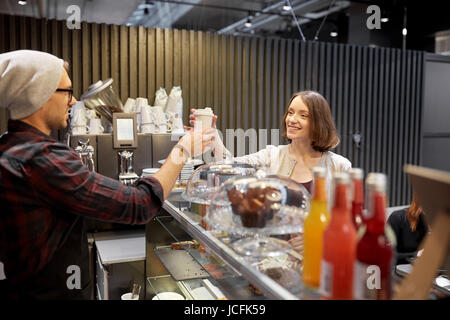 Venditore dando tazza da caffè alla donna il cliente presso il cafe Foto Stock