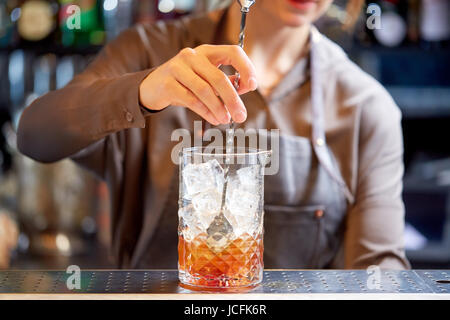 Barista con cocktail di agitatore e di vetro al bar Foto Stock