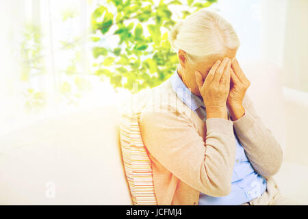 Senior donna che soffre di mal di testa o dolore Foto Stock