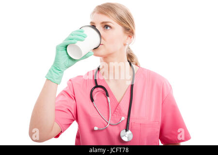 Bionda infermiere medico lady sorseggiando dalla tazza di caffè isolato su sfondo bianco con copia spazio di testo Foto Stock