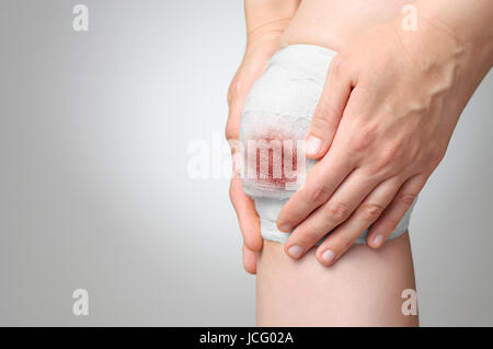 Ferite dolorose ginocchio con bianco Benda di garza Foto Stock