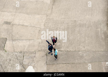 La gente sul molo a Whitby preso forma la parte superiore del faro. Foto Stock