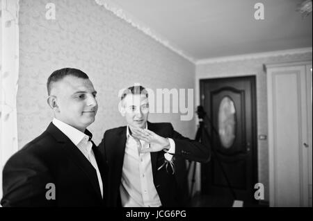 Groomsman e miglior uomo o groomsmen in piedi in un govern camera. Foto in bianco e nero. Foto Stock