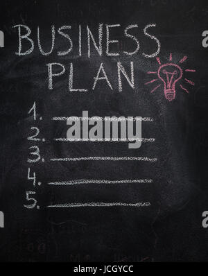 Business plan elenco e lampadina rossa scritto e disegnato con un gessetto sulla lavagna Foto Stock