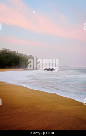 Luna tramonta al sorgere del sole lungo la North Shore a Spiaggia Lumahai alle Hawaii dell Isola di Kauai. Foto Stock