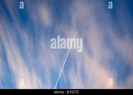 Traccia di due aeromobili in parallelo nel cielo di sunrise. Sentieri di vapore da compagnia di carburante sul bel mattino cloudscape Foto Stock
