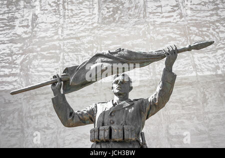 Il bronzo di un soldato italiano statua con arrotolato a bandiera Foto Stock