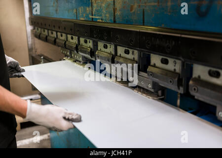 Lavoratore di operare la piegatura di un foglio di alluminio. Foto Stock