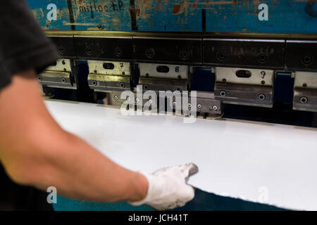 Lavoratore di operare la piegatura di un foglio di alluminio. Foto Stock