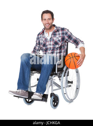 Uomo in carrozzella con la pallacanestro. Isolato su bianco Foto Stock