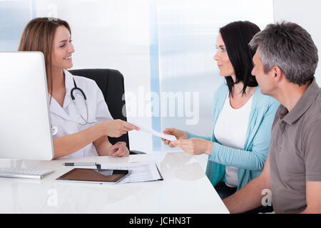 Coppia felice tenendo dando carta dal medico Foto Stock