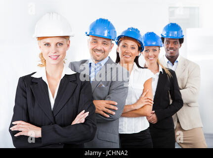 Gruppo di Felice multirazziale architetti in piedi in una riga Foto Stock