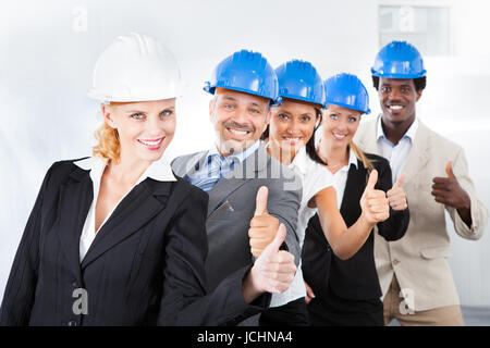 Gruppo di Felice multirazziale architetti in piedi in una riga Foto Stock