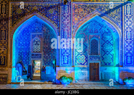 Negozio di illuminato di atrium di Sher Dor madrasah di notte, Registan, Samarcanda, Uzbekistan Foto Stock