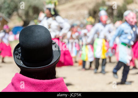 Donna indigena in abiti tradizionali a guardare una danza tradizionale sull' isola del sole sul lato boliviana del Lago Titicaca Foto Stock