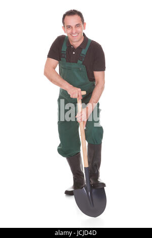 Felice LAVORATORE MASCHILE tenendo una pala su sfondo bianco Foto Stock