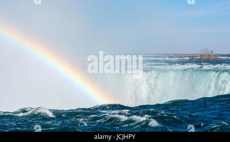 Acqua rushing e cadendo su una battuta di formare una nebbia che genera un arcobaleno. Foto Stock