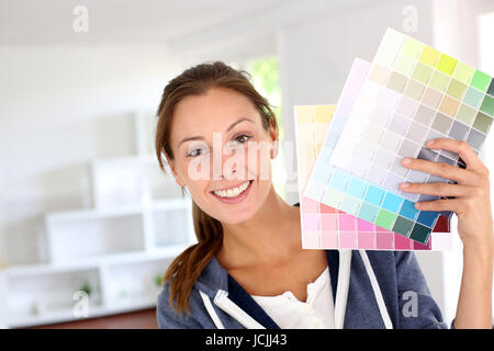 Sorridente ragazza con i grafici a colori per decorare house Foto Stock