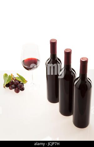 Rotwein im Glas mit Frucht, Blätter und Weinflasche Foto Stock