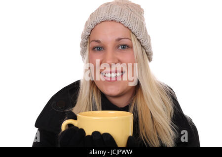 Junge blonde Frau beim Trinken einer Tasse Tee im Winter, isoliert vor einem weissen Hintergrund Foto Stock