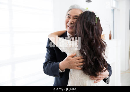 Ritratto di sorridere padre e figlia avvolgente Foto Stock