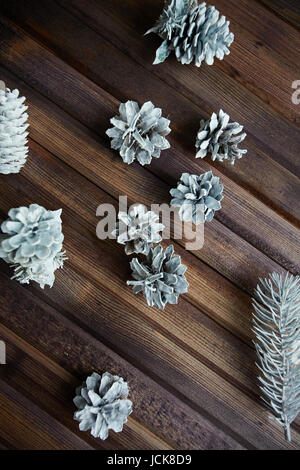 Decorativo coni di argento e di conifere su sfondo di legno Foto Stock