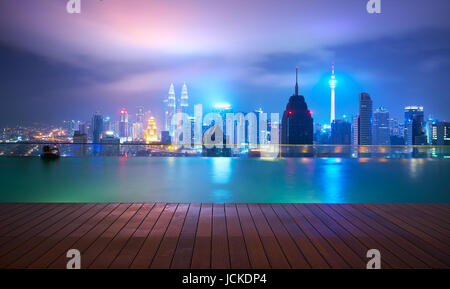 Dopo la notte piovosa, nella parte superiore del tetto della piscina, visitatori nuotare mentre gode di splendida vista dello skyline della citta' ,Kuala Lumpur, Malesia. Foto Stock