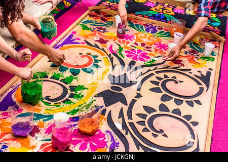 Antigua Guatemala - aprile 13, 2017: realizzazione di segatura di legno tinto quaresima tappeto per la processione in città con più famosi alle celebrazioni della Settimana Santa in america latina Foto Stock