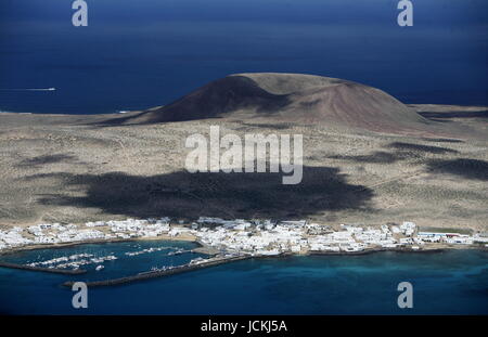 La Isla Graciosa con il villaggio di Caleta del Sebothe dal Mirador del Rio vista sull'isola di Lanzarote su delle isole Canarie in Spagna nell'Oceano Atlantico. sull'isola di Lanzarote su delle isole Canarie in Spagna nell'Oceano Atlantico. Foto Stock