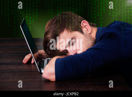 Digital immagine composita del giovane uomo che dorme sul computer portatile alla reception Foto Stock