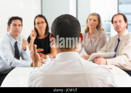 Vista da dietro il CEO di riunione degli indirizzi in sala riunioni Foto Stock